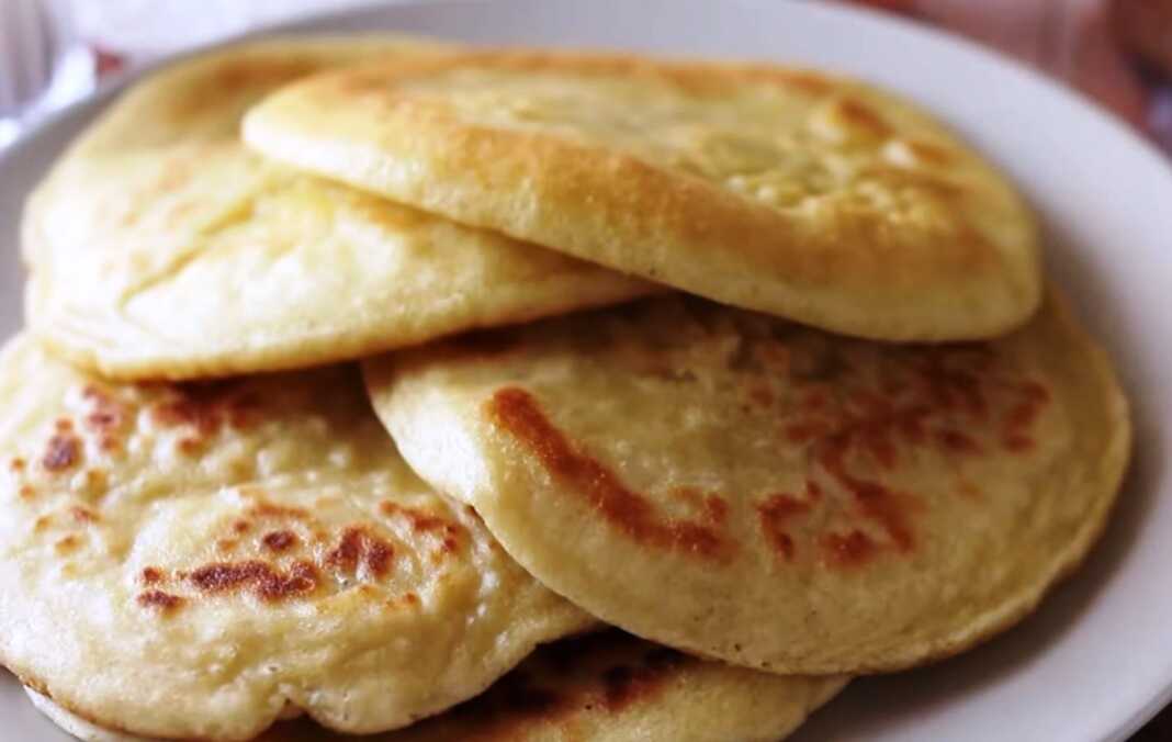 Μικρές χρυσαφένιες πιτούλες που τηγανίζονται σε αντικολλητικό σκεύος, με αφράτη υφή και ροδισμένη όψη