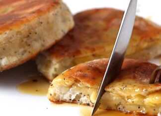 Χρυσαφένιες τηγανίτες από ζύμη τυριού κρέμας γεμιστές με κομμάτια μπανάνας σερβιρισμένες με μέλι σε λευκό πιάτο