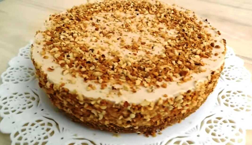 Κρύο κέικ φουντουκιού με βελούδινη κρέμα, καλυμμένο με τριμμένα φουντούκια, σερβιρισμένο σε πιάτο.