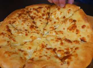 Στρογγυλό χρυσαφένιο χατσαπούρι γεμισμένο με μείγμα τυριών γκούντα και φέτας μόλις βγήκε από τον φούρνο και αχνίζει