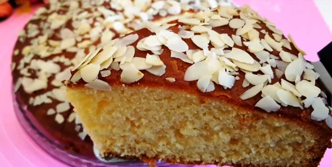 Σπιτικό κέικ αμυγδάλου σε πυρέξ αλειμμένο με γυαλιστερή μαρμελάδα βερίκοκο και πασπαλισμένο με τραγανό φιλέ αμυγδάλου