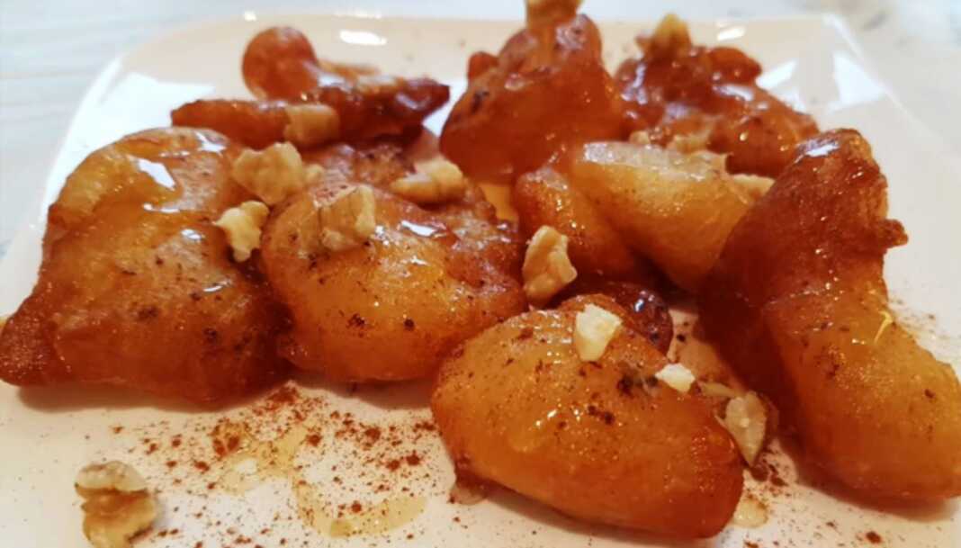 Τραγανοί και Αφράτοι Λουκουμάδες με μέλι και κανέλα σε πιάτο.