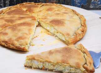 Μια ολόκληρη χωριάτικη τυρόπιτα στο ταψί με χρυσαφένιο τραγανό φύλλο, χαραγμένη σε τετράγωνα κομμάτια