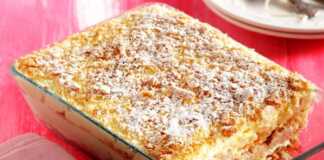 Ένα ταψί εύκολου μιλφέιγ σε ένα πιάτο, με στρώσεις μπισκότων και κρέμας, πασπαλισμένο με άχνη ζάχαρη.