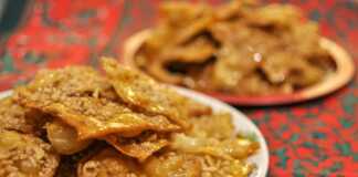 Τραγανά ξεροτήγανα σερβιρισμένα σε πιατέλα, πλούσια πασπαλισμένα με μέλι και ψιλοκομμένα καρύδια.
