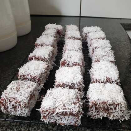 freskopsimena-Lamingtons2-420x420 Τετράγωνα αφράτα κεκάκια καλυμμένα με σκούρο γλάσο σοκολάτας και άσπρη τριμμένη καρύδα, τοποθετημένα σε σχάρα.