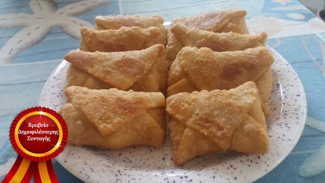 Γκιουζλεμεδες Πιάτο με ζεστούς Γκιουζλεμέδες Μυτιλήνης σε σχήμα φακέλου, με χρυσαφένια κρούστα, έτοιμοι για σερβίρισμα.