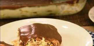 Ένα κομμάτι μπισκοτογλυκό ψυγείου με στρώσεις μπισκότων, κρέμας και επικάλυψης σοκολάτας, σερβιρισμένο σε ένα λευκό πιάτο.