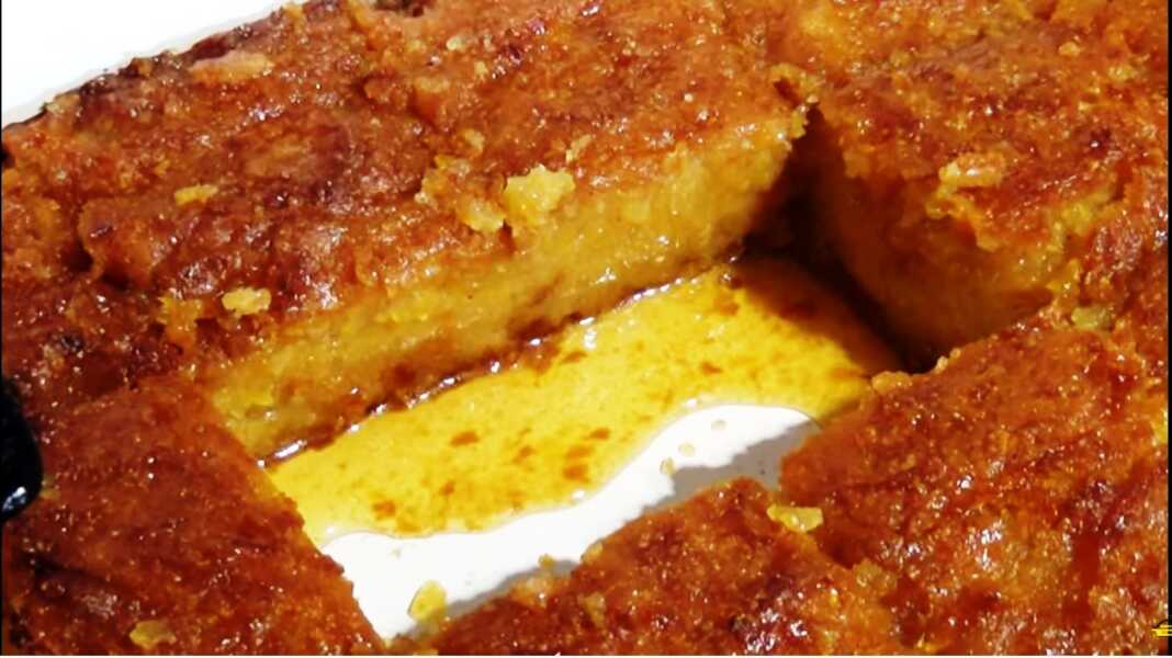 Σιροπιαστό κεικ με κολοκυθα και σιμιγδάλι Ένα κομμάτι σιροπιαστού κέικ κολοκύθας με σιμιγδάλι σε ένα ταψι.