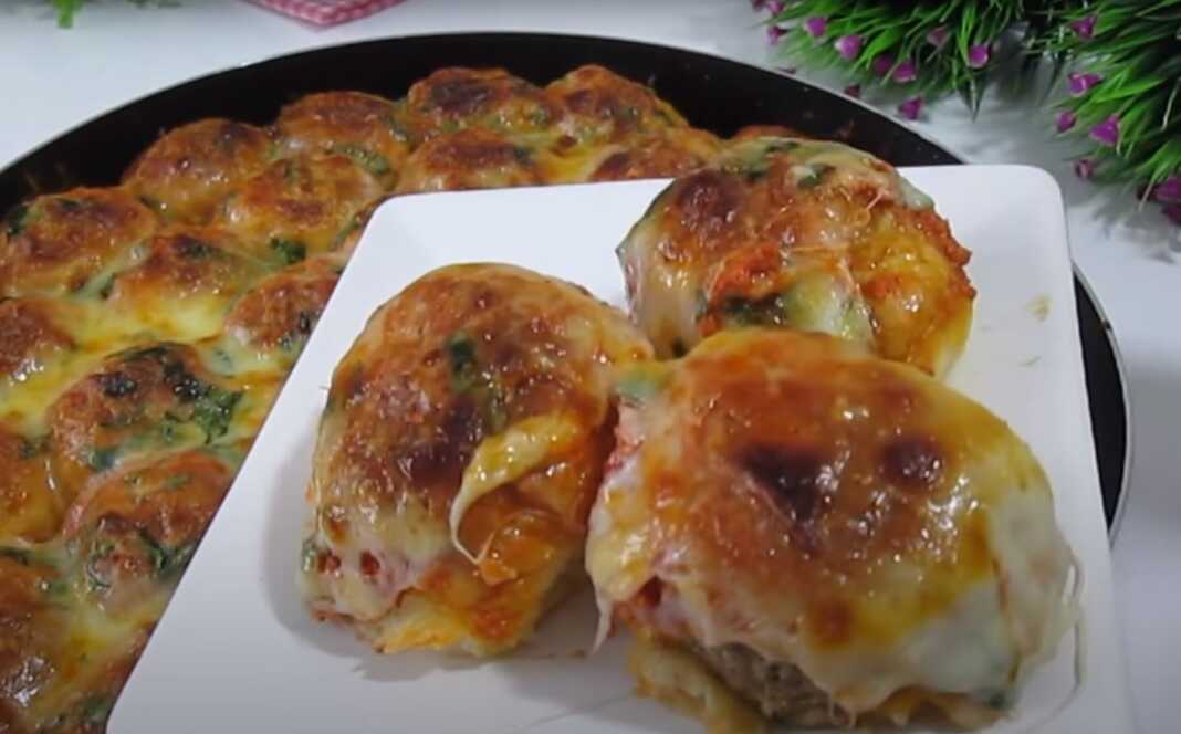 κεφτεδακια σε ζύμη0 Στρογγυλά ψωμάκια με γέμιση κεφτέ, με χρυσαφένια κρούστα, καλυμμένα με λιωμένο τυρί τσένταρ και πασπαλισμένα με φρέσκο μαϊντανό.