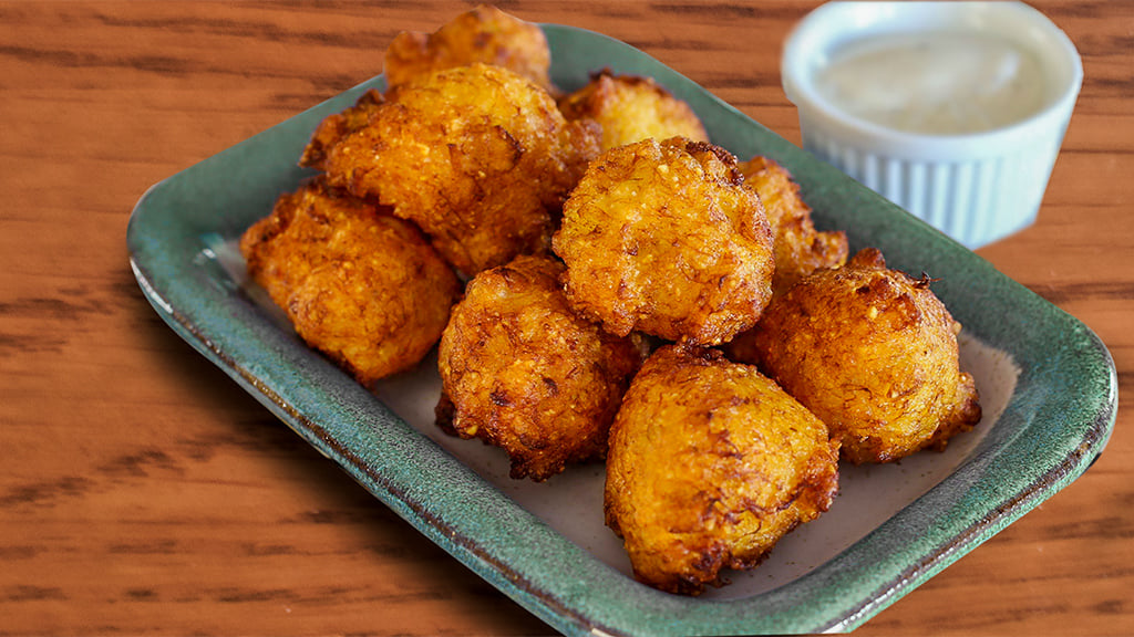 kolokithokeftdes Τηγανισμένοι κολοκυθοκεφτέδες σε ένα πιάτο, με χρυσαφένια κρούστα.