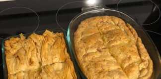 Ολοκληρωμένη Κοτόπιτα με μπεσαμέλ και σφολιάτα, χρυσαφένια και κομμένη σε κομμάτια, σερβιρισμένη σε πιάτο."