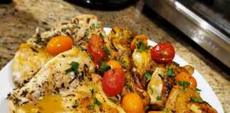 Κοτόπουλο με σάλτσα και μυρωδικά στο τηγάνι Κομμάτια ψημένου κοτόπουλου σερβιρισμένα σε πιάτο με κόκκινη σάλτσα, ντοματίνια και φρέσκα μυρωδικά.