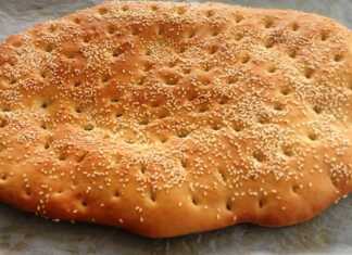 Παραδοσιακή συνταγη λαγανα πασπαλισμένη με μπόλικο σουσάμι πάνω σε ταψί με λαδόκολλα