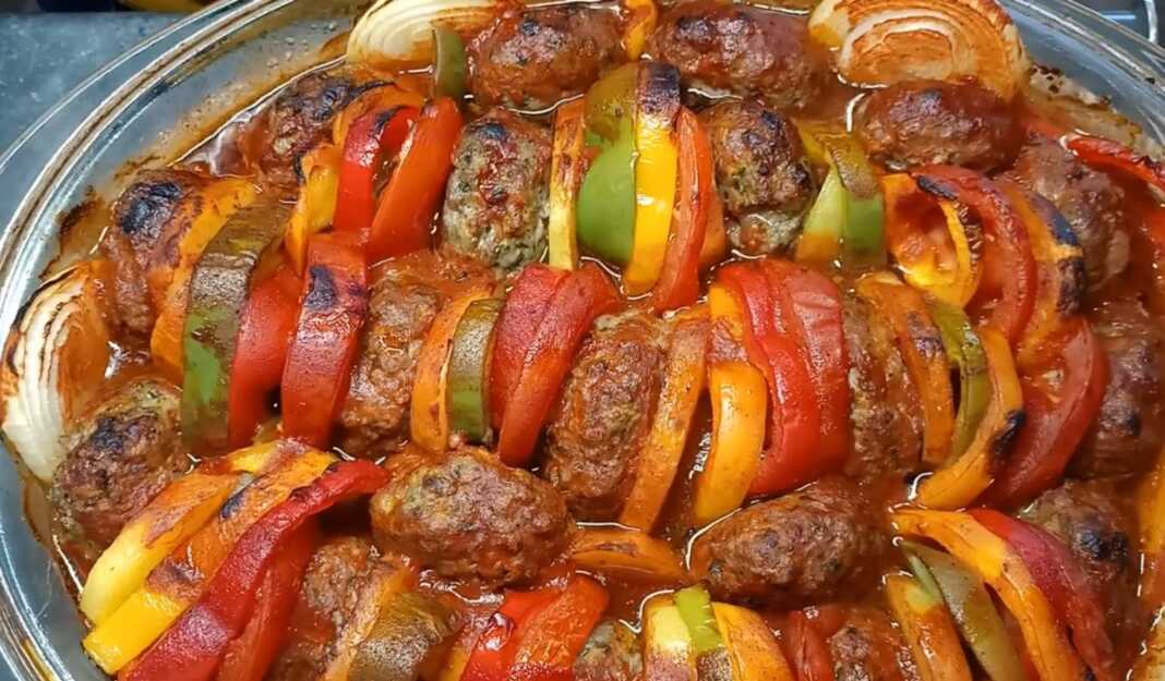 mpiftekiamelaxanika Ταψί με μπιφγτέκια ψημένα ανάμεσα σε χρωματιστές πιπεριές, κρεμμύδια, πατάτες και ντομάτες, περιχυμένα με κόκκινη σάλτσα.