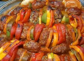 Ταψί με μπιφγτέκια ψημένα ανάμεσα σε χρωματιστές πιπεριές, κρεμμύδια, πατάτες και ντομάτες, περιχυμένα με κόκκινη σάλτσα.