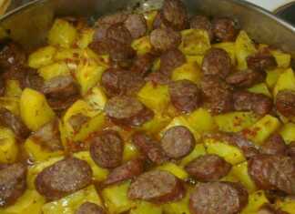 Ταψί με λουκάνικα κομμένα, πατάτες και πράσα ψημένα στο φούρνο με χρυσαφένια κρούστα τυριού.