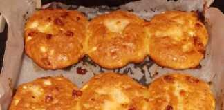 Ενα ταψί με χρυσαφένια, στρογγυλά τυρόψωμα, πασπαλισμένα με αλάτι, έτοιμα για σερβίρισμα.