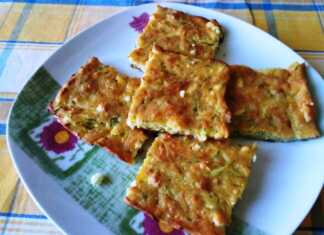 Ένα ταψί με παραδοσιακή μαμαλίγκα που έχει ροδίσει στην επιφάνεια με κομμάτια φέτας και κολοκυθάκια