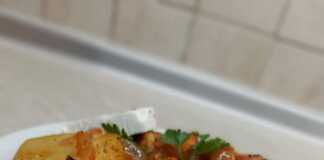 Ένα πίατο από στρογγυλές φέτες μελιτζάνας και πατάτας, κομμένα κρεμμύδια, φέτες ντομάτας και κόκκινη σάλτσα.