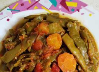 Παραδοσιακά φασολάκια λαδερά με σάλτσα ντομάτας και καρότα, σερβιρισμένα σε βαθύ πιάτο με φρέσκο μαϊντανό.