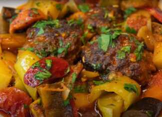 Ταψί με ροδοκοκκινισμένα κεφτεδάκια ανάμεσα σε πολύχρωμες πιπεριές μελιτζάνες κολοκυθάκια και πατάτες περιχυμένα με πλούσια σάλτσα ντομάτας
