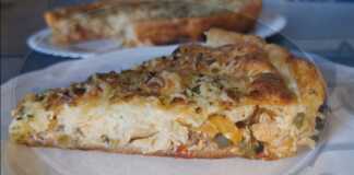 Λαχταριστή κοτόπιτα με χρυσαφένια σφολιάτα, γεμάτη κοτόπουλο, πολύχρωμες πιπεριές και λιωμένα τυριά, έτοιμη να κοπεί σε τετράγωνα κομμάτια.