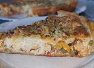 Λαχταριστή κοτόπιτα με χρυσαφένια σφολιάτα, γεμάτη κοτόπουλο, πολύχρωμες πιπεριές και λιωμένα τυριά, έτοιμη να κοπεί σε τετράγωνα κομμάτια.