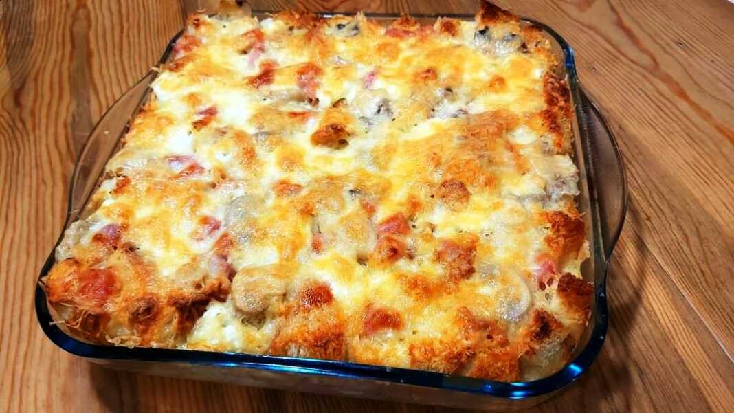 MpagiatikoPsomi Μια αφράτη και ροδοκοκκινισμένη πίτα στο πυρέξ φτιαγμένη με κυβάκια ψωμιού και λιωμένο κίτρινο τυρί στην επιφάνεια