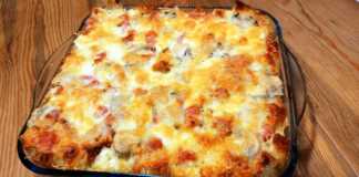 Μια αφράτη και ροδοκοκκινισμένη πίτα στο πυρέξ φτιαγμένη με κυβάκια ψωμιού και λιωμένο κίτρινο τυρί στην επιφάνεια