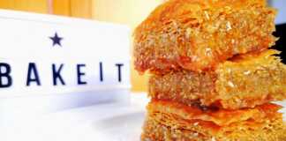 Μια χρυσαφένια, σιροπιαστή Σουσαμόπιτα κομμένη σε κομμάτια, με ξυλάκια γαρίφαλλο στην επιφάνεια