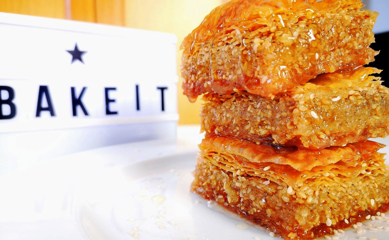 Sousamopita1 Μια χρυσαφένια, σιροπιαστή Σουσαμόπιτα κομμένη σε κομμάτια, με ξυλάκια γαρίφαλλο στην επιφάνεια