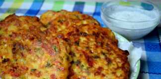 Ένα πιάτο με τηγανητούς, στρογγυλούς κεφτέδες που φαίνονται να περιέχουν κομματάκια πιπεριάς και τυριού.