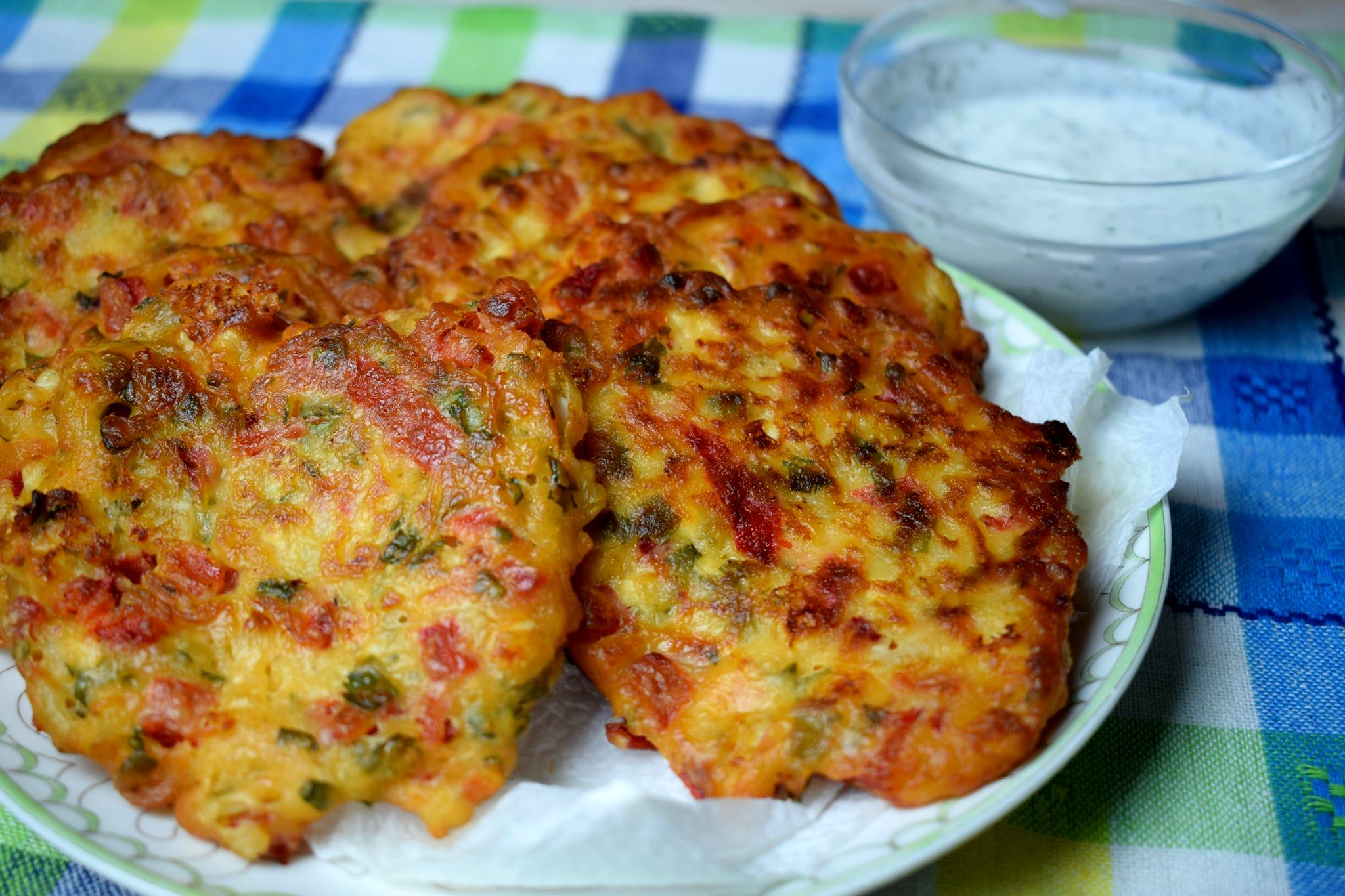 keftedesPiperiesFeta0 Ένα πιάτο με τηγανητούς, στρογγυλούς κεφτέδες που φαίνονται να περιέχουν κομματάκια πιπεριάς και τυριού.