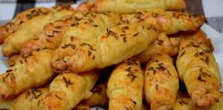 Τα ψημένα **Ρολάκια Τυριού** με κύμινο σε πιατέλα, έτοιμα για σερβίρισμα