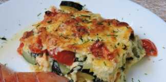 Χρυσόχρωμο ογκρατέν με κολοκυθάκια, ντομάτα και λιωμένο τυρί, μόλις βγαλμένο από τον φούρνο, σε πυρίμαχο σκεύος.