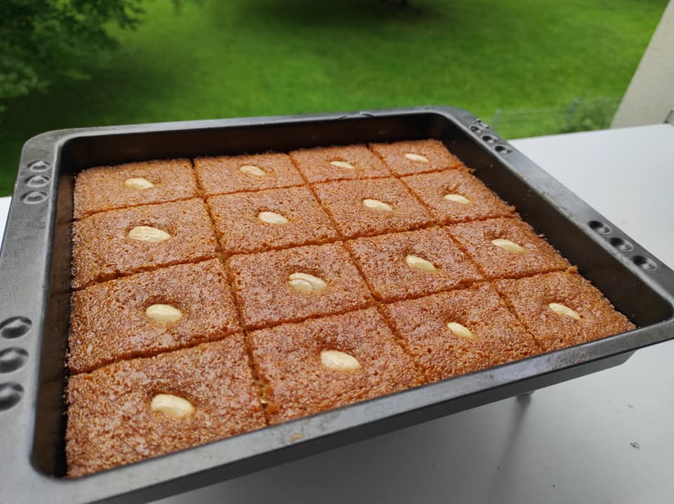 Αφράτο και σιροπιαστό ρεβανί με καρύδα, κομμένο σε τετράγωνα κομμάτια, έτοιμο για σερβίρισμα.