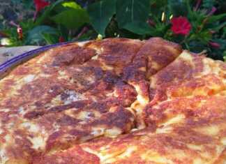 Μια ολόκληρη Τυρόπιτα στο τηγάνι, με χρυσαφένιο χρώμα, σερβιρισμένη σε ξύλινη πιατέλα