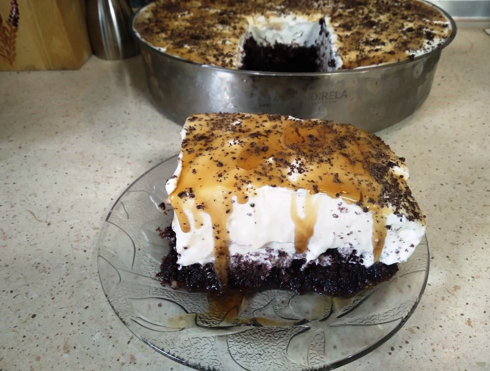 giaourtoglikonew Ένα κομμάτι Γιαουρτογλυκό με στρώσεις σοκολατένιου παντεσπάνι και λευκής κρέμας γιαουρτιού, γαρνιρισμένο με τριμμένη σοκολάτα.