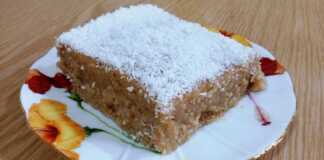 Ένα κομμάτι σιμιγδαλένιου χαλβά πασπαλισμένο με ξέσματα καρύδας, σερβιρισμένο σε πιάτο.