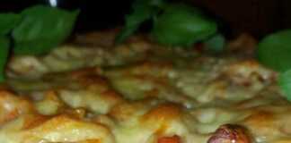 Ένα πυρέξ γεμάτο χρυσαφένια μακαρόνια φούρνου με λιωμένο κίτρινο τυρί στην επιφάνεια.