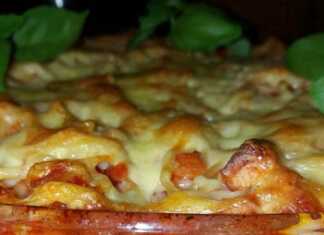 Ένα πυρέξ γεμάτο χρυσαφένια μακαρόνια φούρνου με λιωμένο κίτρινο τυρί στην επιφάνεια.