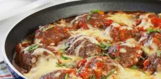 Κεφτεδάκια με σάλτσα ντομάτας στο φούρνο, πασπαλισμένα με λιωμένο τυρί και φρέσκο μαϊντανό, μέσα σε πυρίμαχο σκεύος