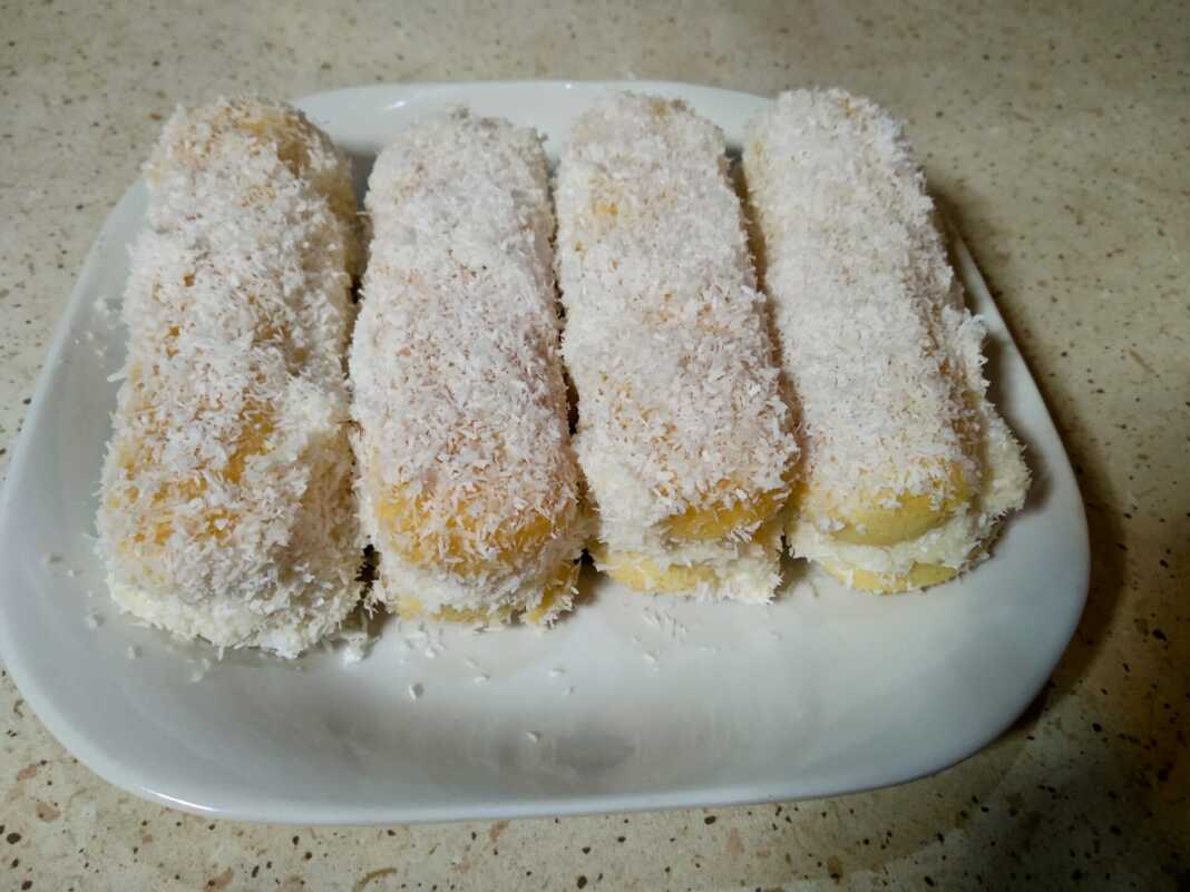 Έτοιμα Σαντουιτσάκια Σαβαγιάρ με Κρέμα, κυλισμένα σε ινδοκάρυδο, σε πιατέλα.