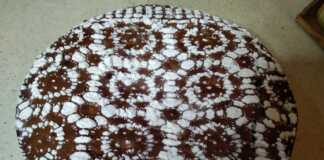 Μία ολόκληρη Φανουρόπιτα με 9 υλικά, πασπαλισμένη με ζάχαρη άχνη, σε πιατέλα σερβιρίσματος