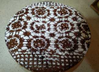 Μία ολόκληρη Φανουρόπιτα με 9 υλικά, πασπαλισμένη με ζάχαρη άχνη, σε πιατέλα σερβιρίσματος