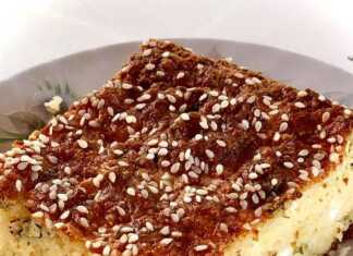 Φετόπιτα Αφράτη αλμυρή πίτα, με χρυσαφένια κρούστα, πασπαλισμένη με σουσάμι, κομμένη σε μερίδες μέσα σε ταψί.