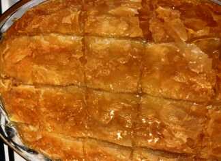 Τετράγωνο κομμάτι γαλακτομπούρεκου με χρυσαφένιο, τραγανό φύλλο κρούστας και πλούσια, κρεμώδη γέμιση να φαίνεται στο εσωτερικό.