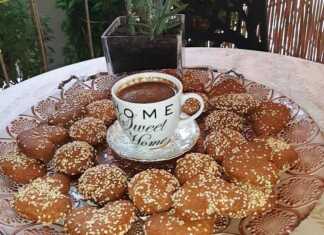 Στρογγυλά νηστίσιμα βουτήματα καρύδας, ρολαρισμένα σε σουσάμι και κανέλα, τοποθετημένα σε σχάρα ή πιατέλα.