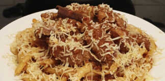 Αυθεντική Κερκυραϊκή Παστιτσάδα Πιατέλα με αυθεντική Κερκυραϊκή Παστιτσάδα με κόκορα, ζυμαρικά και άφθονο τριμμένο τυρί.